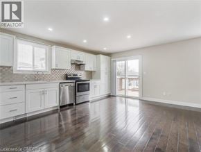Hamilton apartment for rent - A spacious kitchen with white cabinets and a checkered backsplash.