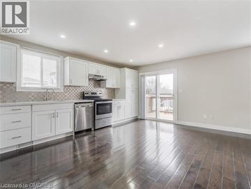 Hamilton apartment for rent - A spacious kitchen with white cabinets and a checkered backsplash.