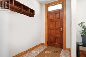 Ottawa duplex for rent - A brown door is in a white room with a plant on a table.