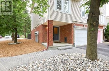 Ottawa townhouse for rent - A house with a red brick wall and a white garage door.