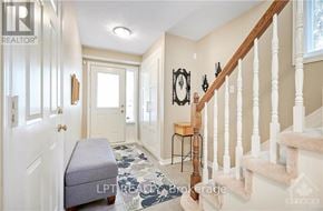 Ottawa townhouse for rent - A hallway with a staircase and a bench.