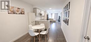 Welland (Broadway) townhouse for rent - A kitchen with black appliances and white cabinets.