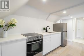 Collingwood condo for rent - A modern kitchen with white cabinets and stainless steel appliances.