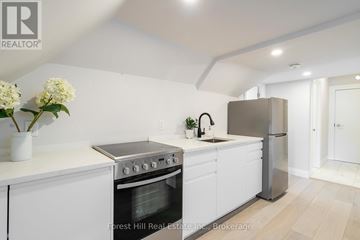 Collingwood condo for rent - A modern kitchen with white cabinets and stainless steel appliances.