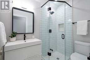 Collingwood condo for rent - A white bathroom with a glass shower stall and a white toilet.