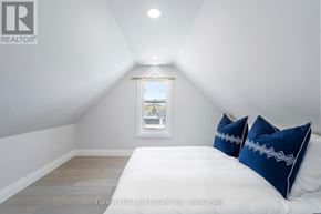 Collingwood condo for rent - A bedroom with a bed, two pillows, and a window.
