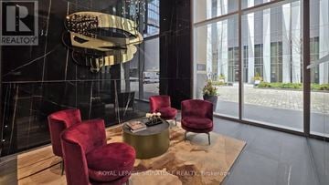 Toronto (Annex) condo for rent - A modern living room with a glass table and red chairs.