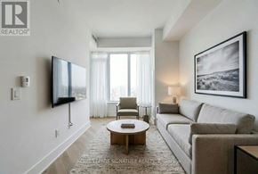Toronto (Annex) condo for rent - A living room with a couch, chair, and television.