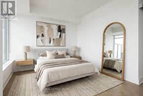 Toronto (Annex) condo for rent - A bedroom with a large bed, a painting on the wall, and a mirror on the wall.