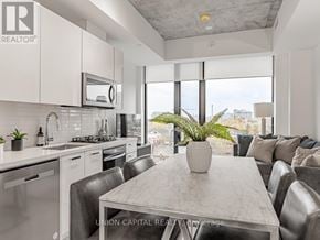 Toronto (Kensington-Chinatown) condo for rent - A modern kitchen with a dining table and chairs.