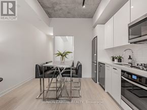 Toronto (Kensington-Chinatown) condo for rent - A modern kitchen with a dining table and chairs.
