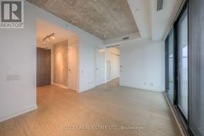 Toronto (Waterfront Communities) condo for rent - A spacious room with wooden flooring and a ceiling with exposed beams.