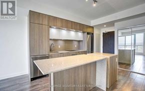 Toronto (Regent Park) condo for rent - A modern kitchen with wooden cabinets and a central island.