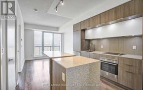 Toronto (Regent Park) condo for rent - A modern kitchen with wooden cabinets and a central island.