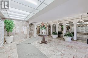 Toronto (The Beaches) multi-family for rent - A spacious room with marble flooring and a row of arched windows.