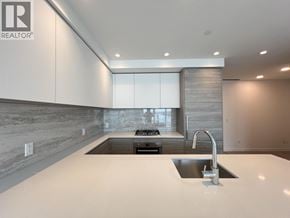 New Westminster apartment for rent - A modern kitchen with a large island and stainless steel sink.