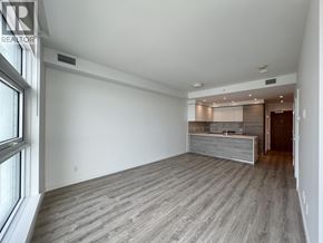 New Westminster apartment for rent - A spacious room with wooden flooring and a large window on the left side.
