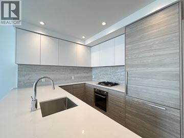 New Westminster apartment for rent - A modern kitchen with a sink and a stove top.