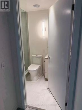 Toronto (Mount Pleasant West) condo for rent - A white toilet in a small bathroom with a glass door.