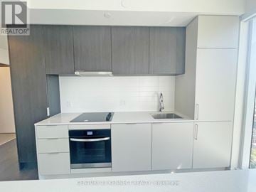 Toronto (Church-Yonge Corridor) condo for rent - A modern kitchen with white cabinets and a stainless steel dishwasher.