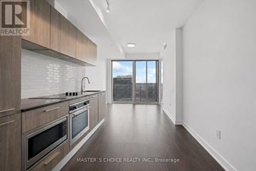 Toronto (Church-Yonge Corridor) condo for rent - A modern kitchen with dark wood cabinets and stainless steel appliances.