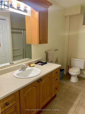 Whitchurch-Stouffville apartment for rent - A bathroom with a white sink and wooden cabinets.