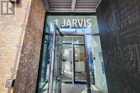 Hamilton (Beasley) condo for rent - The entrance to a building with a glass door and a sign that reads "1 Jarvis.".