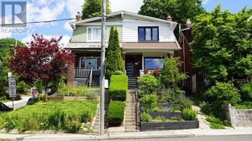 Toronto (Woodbine Corridor) apartment for rent - A house with a green lawn and a sign that says REALTOR.