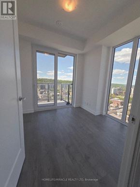 Hamilton (Corktown) condo for rent - A room with a view of the cityscape through large windows.