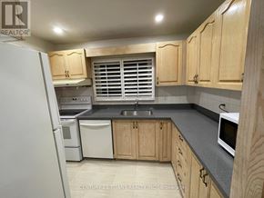 Toronto (Morningside) townhouse for rent - A kitchen with wooden cabinets and a white refrigerator.