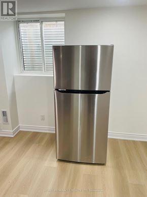 Oakville (Wm Westmount) apartment for rent - A stainless steel refrigerator in a kitchen with wood flooring.