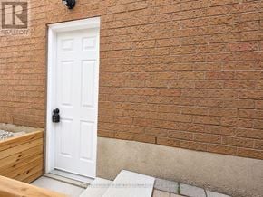 Mississauga (East Credit) apartment for rent - A white door with a black handle is set in a brick wall.
