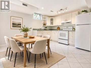 Mississauga (East Credit) apartment for rent - A kitchen with a table and chairs in the foreground and a refrigerator in the background.