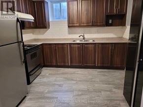 Mississauga (Hurontario) apartment for rent - A kitchen with wooden cabinets and a tiled floor.