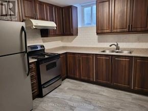 Mississauga (Hurontario) apartment for rent - A kitchen with wooden cabinets and a white fridge.