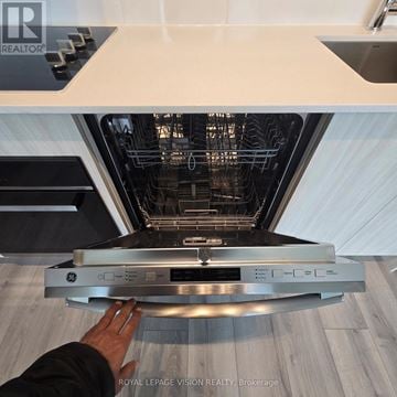 Toronto (Clairlea-Birchmount) condo for rent - A person is opening a stainless steel oven in a modern kitchen.