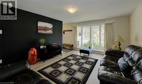 Kitchener apartment for rent - A living room with a black couch and a rug.