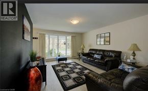 Kitchener apartment for rent - A living room with a black couch and a red vase.