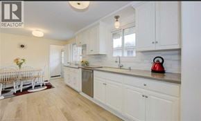 Kitchener apartment for rent - A kitchen with white cabinets and a wooden floor.