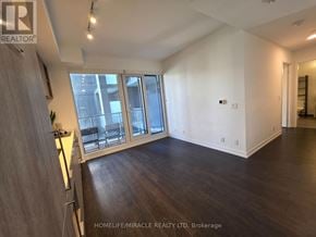 Toronto (Humewood-Cedarvale) condo for rent - A spacious room with wooden floors and a large window.