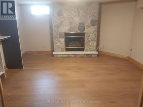 Oshawa (Eastdale) apartment for rent - A room with a stone fireplace and wooden flooring.