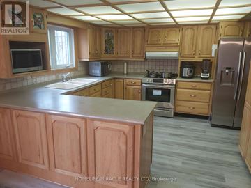 Oshawa (Eastdale) apartment for rent - A kitchen with wooden cabinets and a refrigerator.