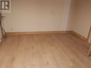 Oshawa (Eastdale) apartment for rent - A room with wooden flooring and a wall with a realtor logo.