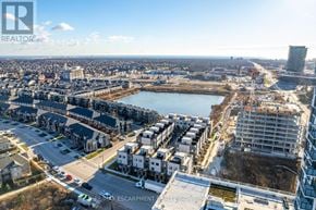 Oakville (Jm Joshua Meadows) condo for rent - A cityscape with a large body of water and buildings under construction.