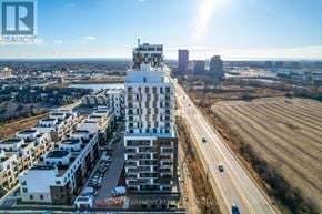 Oakville (Jm Joshua Meadows) condo for rent - A modern multi-story building with a flat roof is situated in a residential area with other buildings and houses.