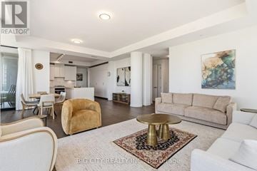 Toronto (Thorncliffe Park) condo for rent - A living room with a white couch, a gold chair, and a rug with a gold table.