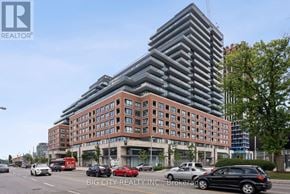 Toronto (Thorncliffe Park) condo for rent - A modern building with a glass facade is the focal point of the image.