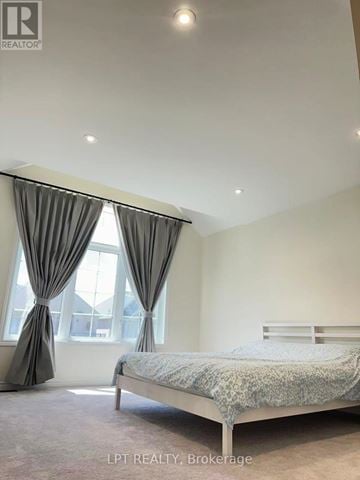 East Gwillimbury (Holland Landing) apartment for rent - A bedroom with a bed, curtains, and a window.