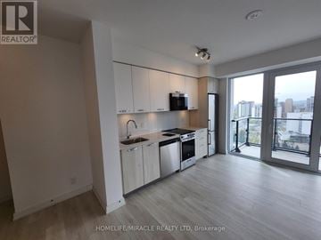 Hamilton (Corktown) condo for rent - A modern kitchen with white cabinets and stainless steel appliances.