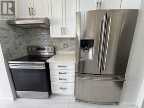 Richmond Hill (Rouge Woods) apartment for rent - A stainless steel refrigerator with a digital display is in the foreground of a kitchen.